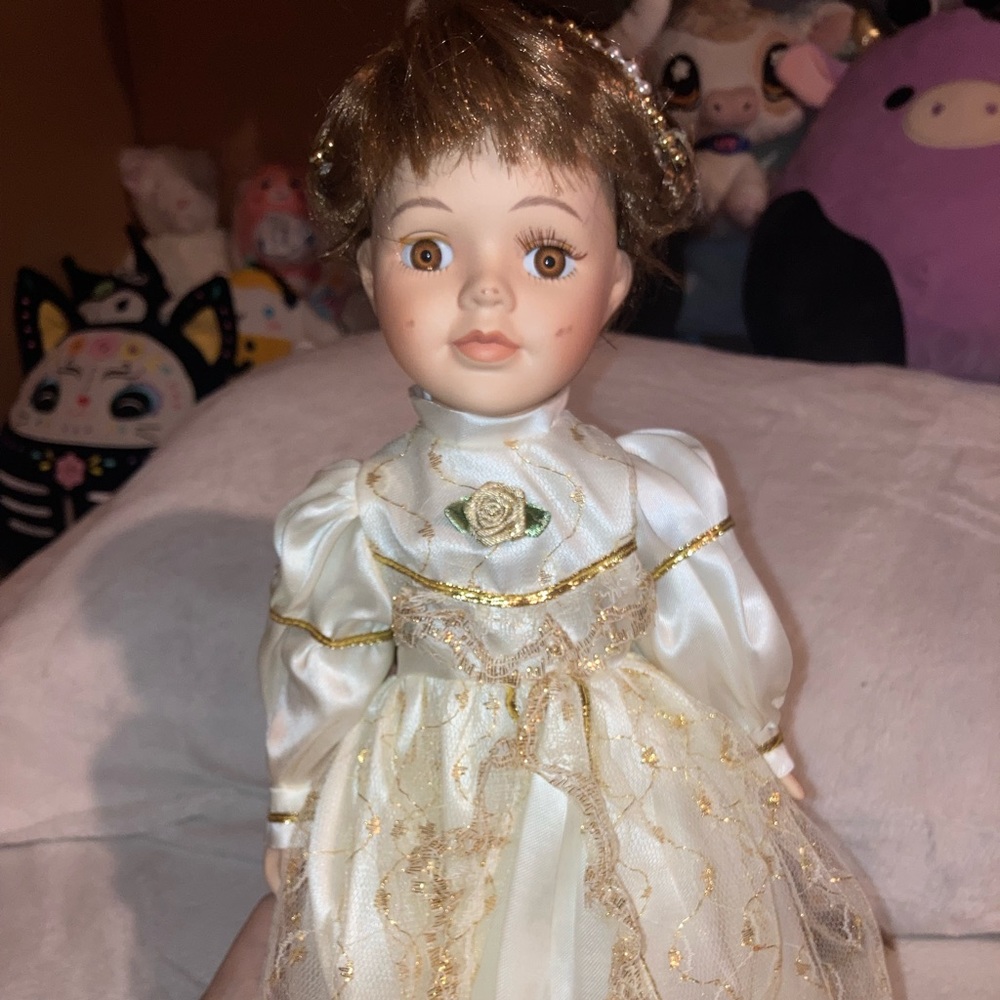 Vintage porcelain doll in white dress with brown hair